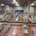 Self-propelled carousel sorting pallets from the palletising stations to the stretch-wrapping stations